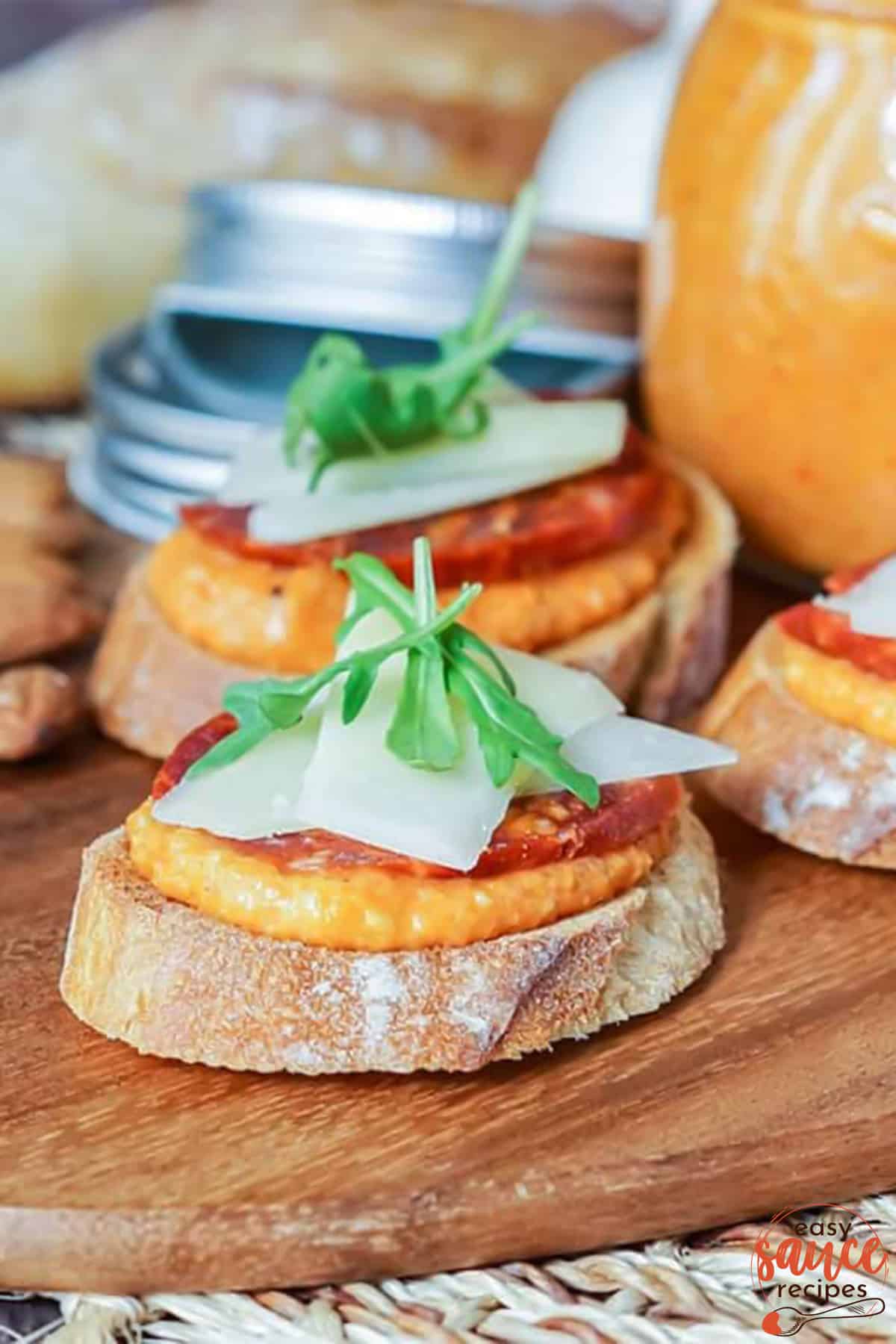 romesco sauce spread on baguettes with sliced chorizo and cheese