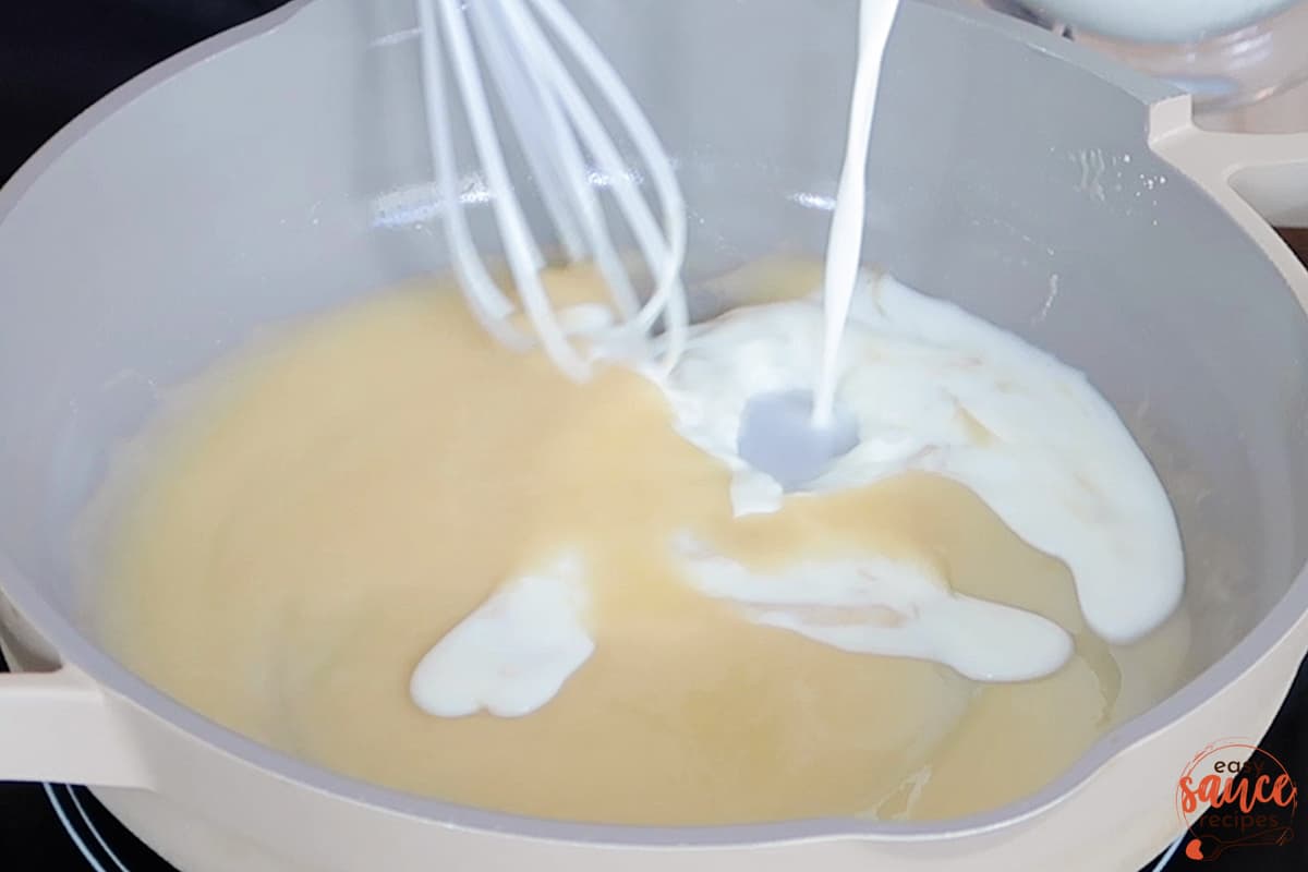 adding milk to roux in a skillet