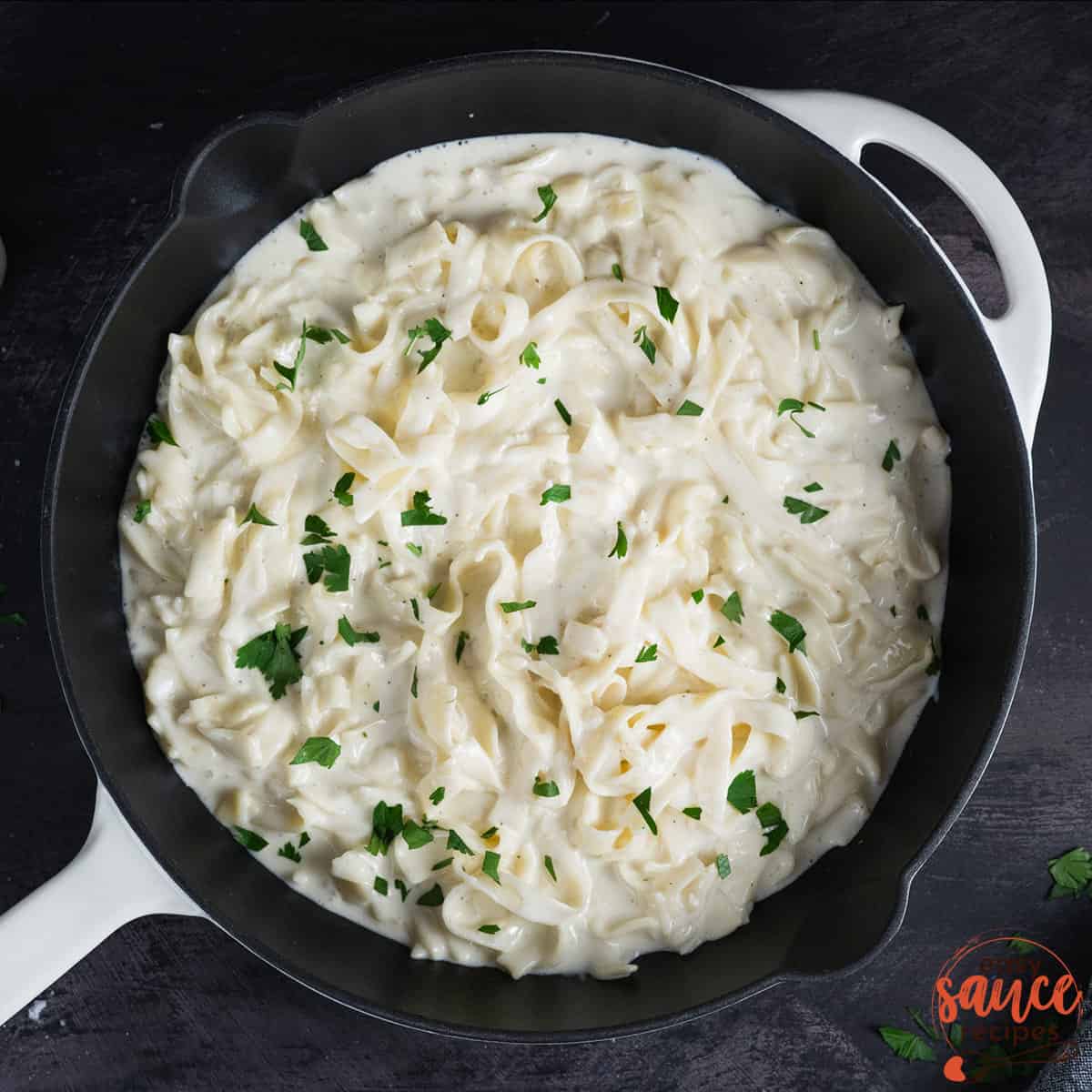 Alfredo in a skillet with fresh parsley on top
