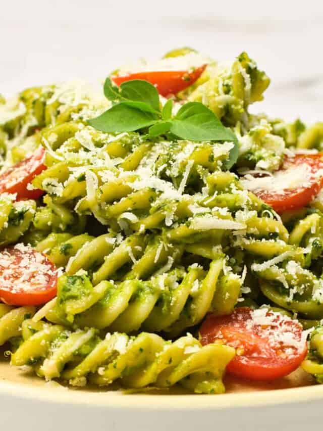 a closeup of pasta with avocado pasta sauce, tomatoes, and cheese