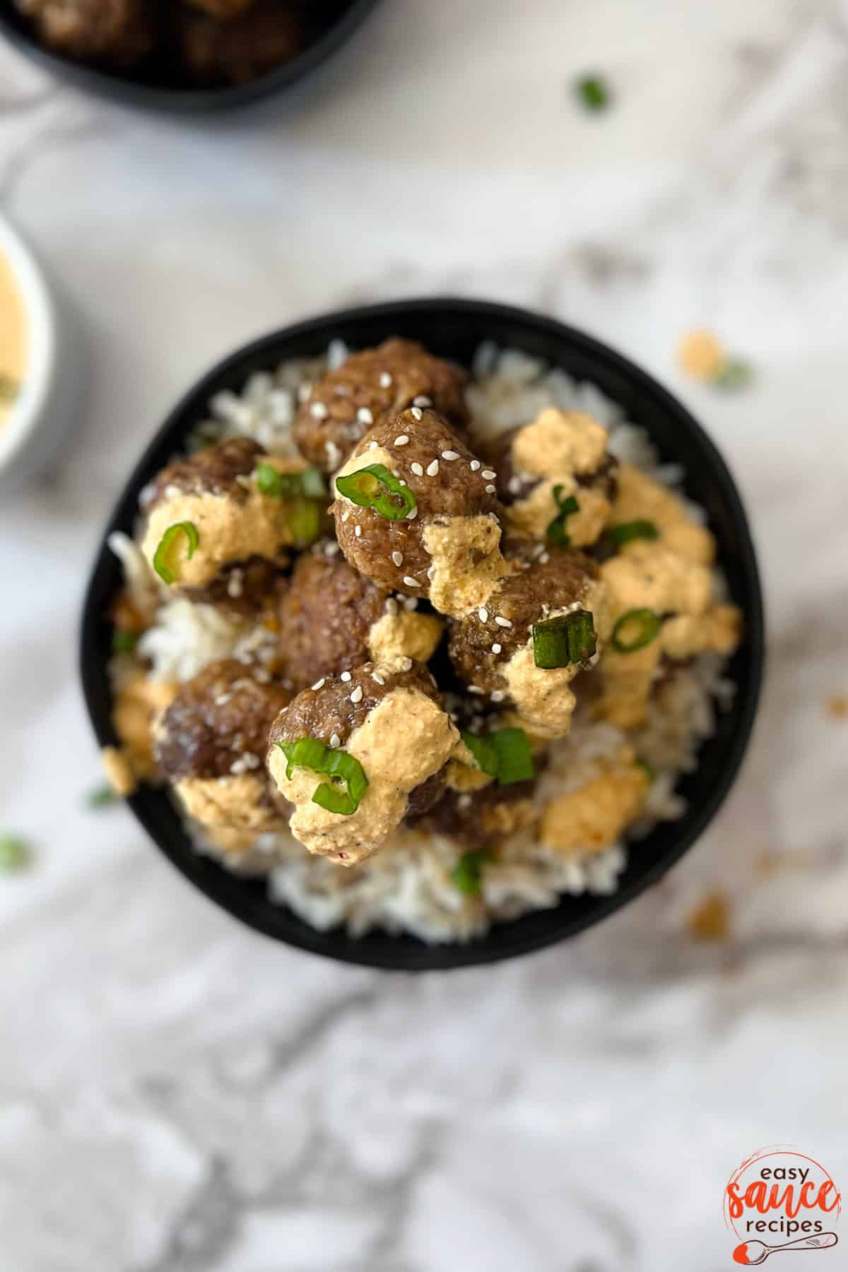 kimchi mayo drizzled over meatballs in white rice