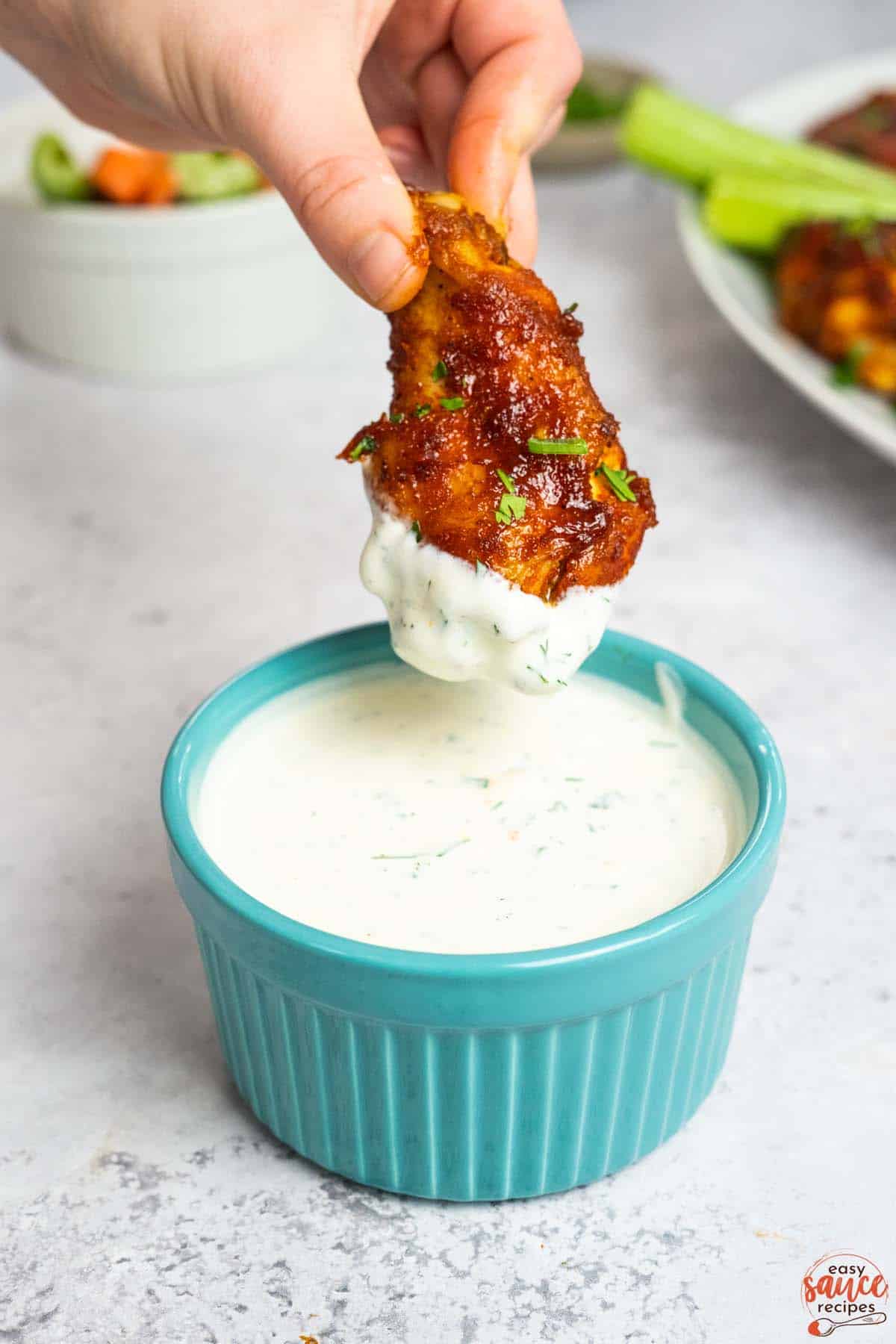 ranch in a blue dish with a chicken wing