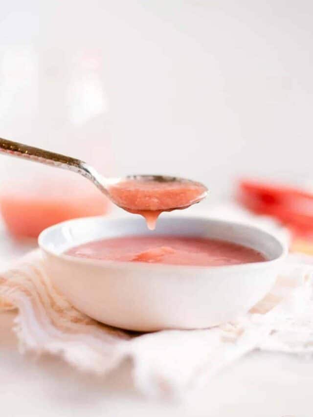 rhubarb sauce dripping into a white bowl from a spoon