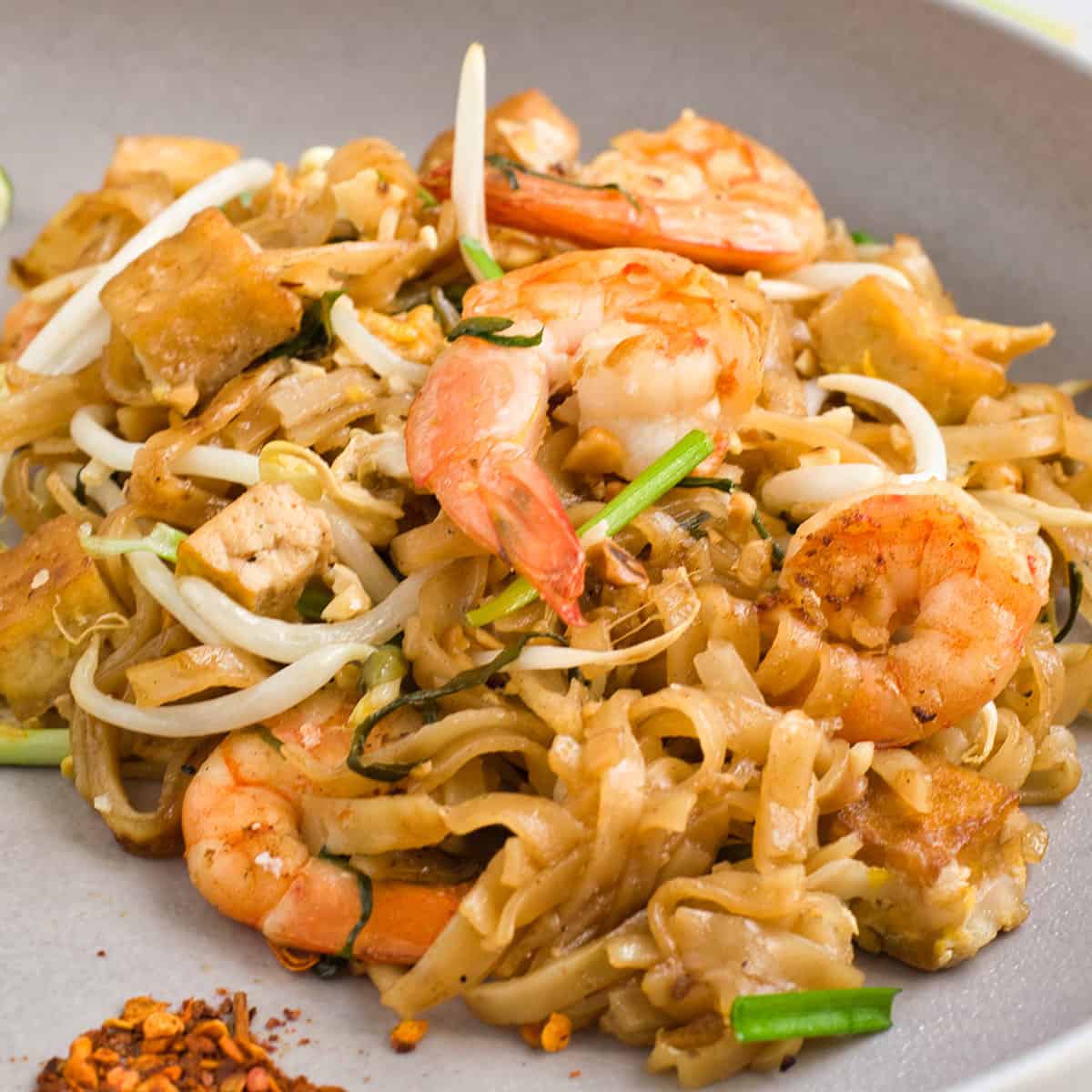 a closeup of a dish of pad thai with shrimp