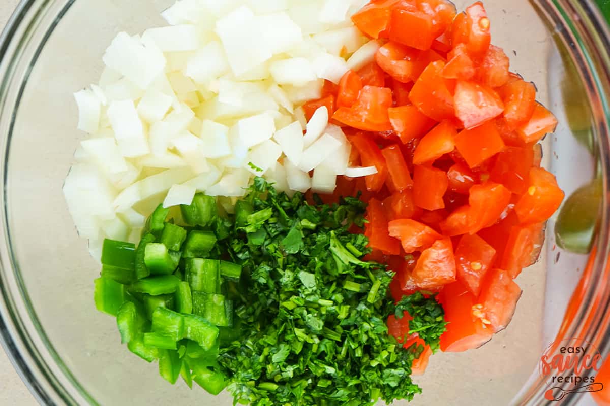 pico de gallo ingredients all chopped up in a clear bowl