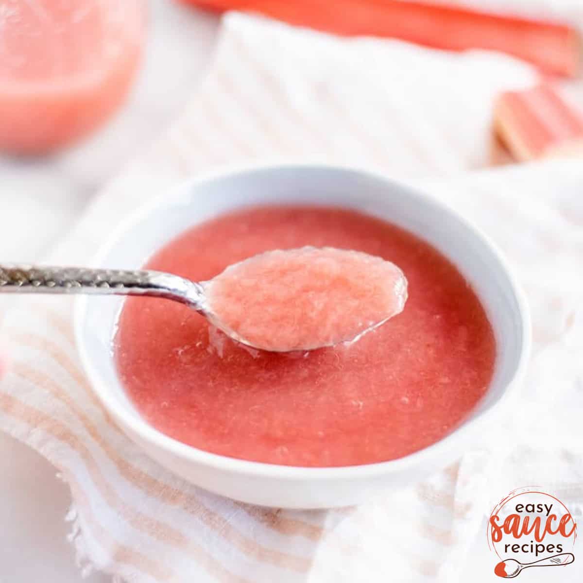 rhubarb sauce in a white bowl with a spoon