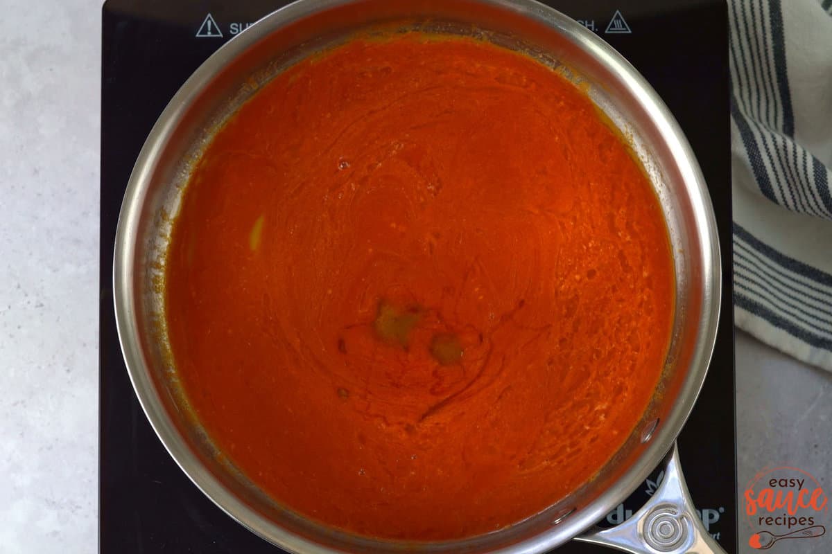 adding honey to buffalo sauce in the skillet