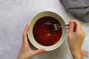 honey and soy sauce added to a bowl being mixed