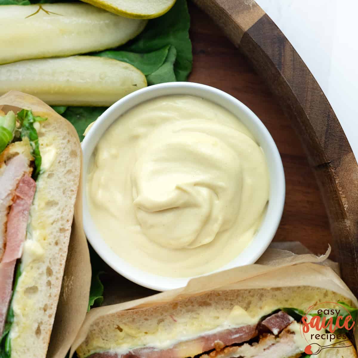 mayo mustard sauce in a ramekin next to pork sandwich