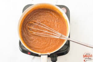 pumpkin butter cooking in a pot with a whisk