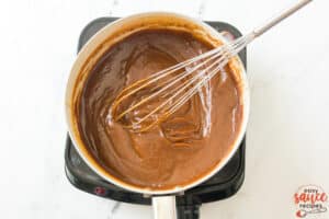 cooked pumpkin butter in a pot with a whisk