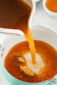 the apple cider vinegar and brown sugar being added to a saucepan