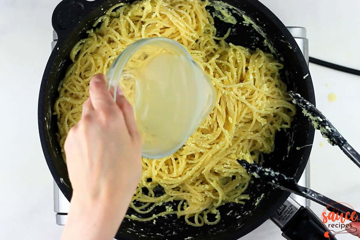 pasta water being added to the pot of pasta and egg and cheese