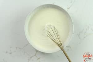 crema in a white dish with a whisk