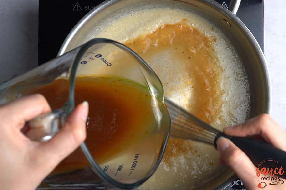 pouring beef broth inside of roux
