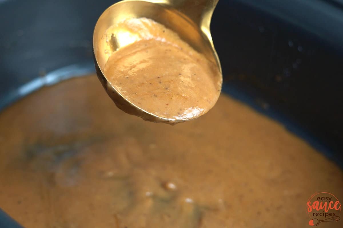 pouring pot roast gravy in slow cooker